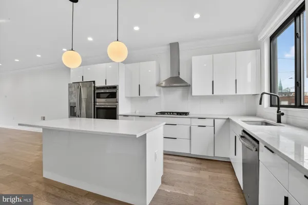 a kitchen with stainless steel appliances granite countertop a sink a stove a oven a counter top space and cabinets