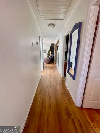 a view of a hallway with wooden floor