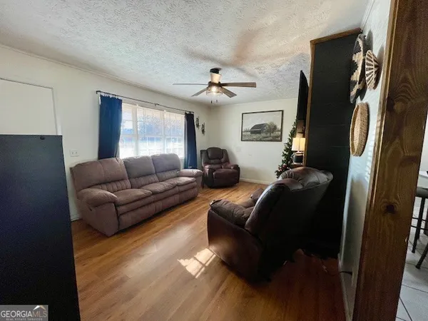 a living room with furniture a ceiling fan and a window