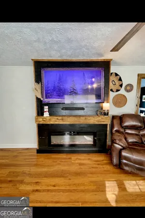 a living room with stainless steel appliances kitchen island granite countertop a stove and a microwave