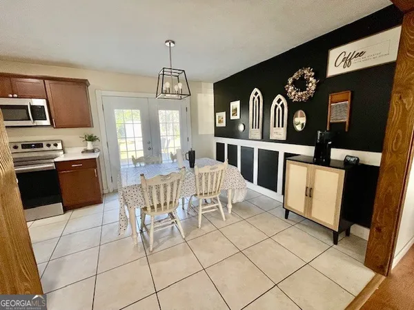 a kitchen with stainless steel appliances kitchen island granite countertop a refrigerator a stove top oven and white cabinets