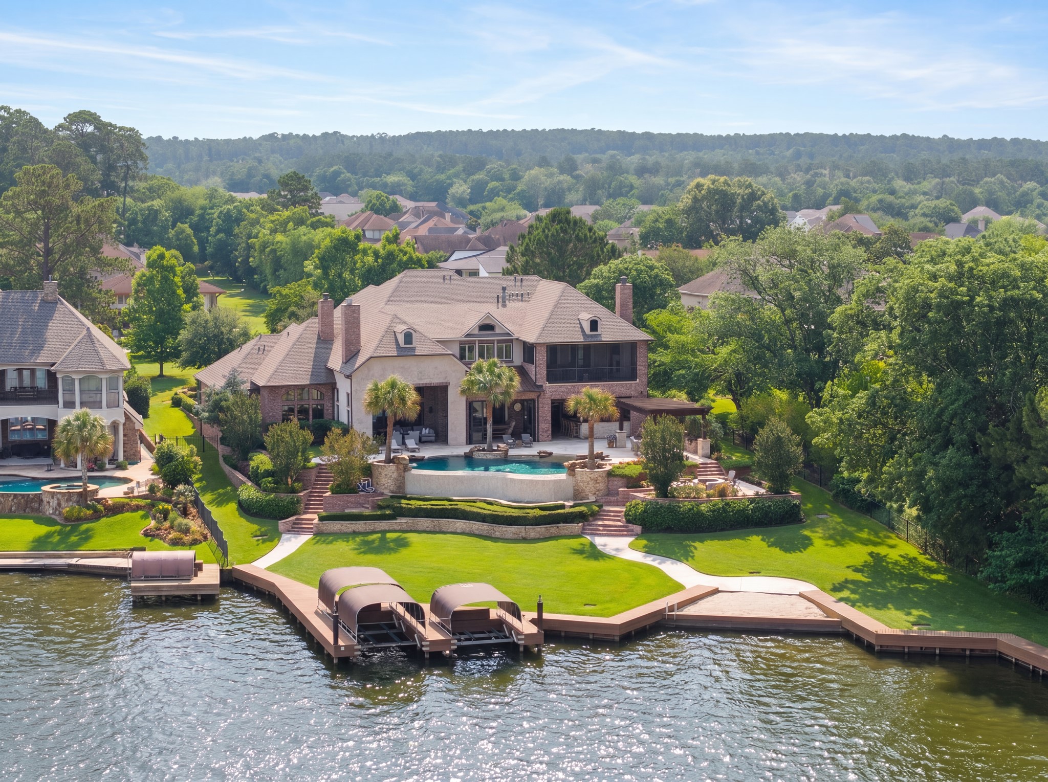 12349 Longmire Trace Conroe, TX 77304 - Photo 1 of 48 Resort-style lakefront retreat with expansive dock, covered boat slips, and a stunning pool terrace.