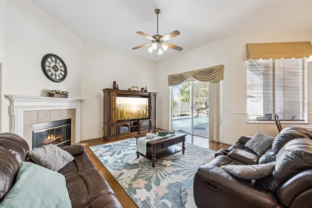 a living room with furniture a large window and a fireplace
