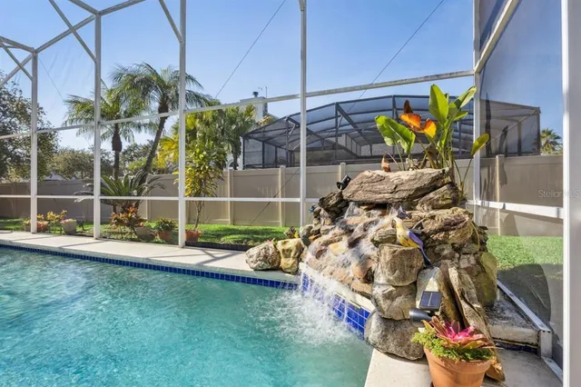 a view of a swimming pool with a yard and plants