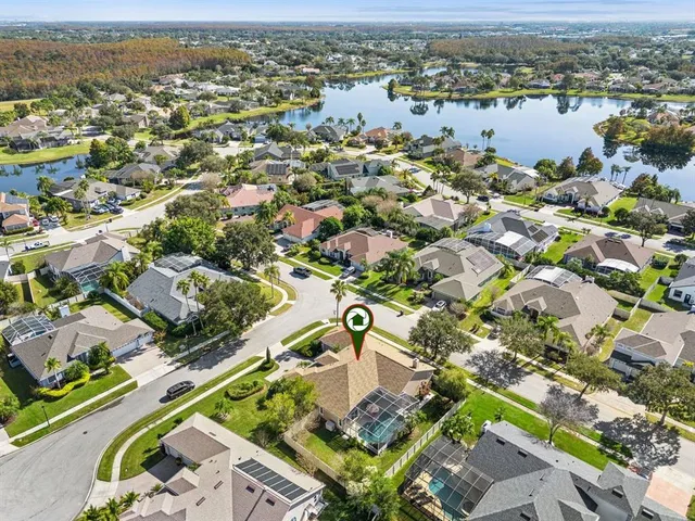 an aerial view of a house with a garden and lake view