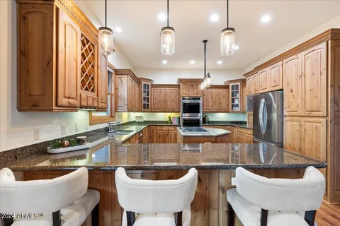 a kitchen with stainless steel appliances granite countertop a stove a refrigerator and a sink