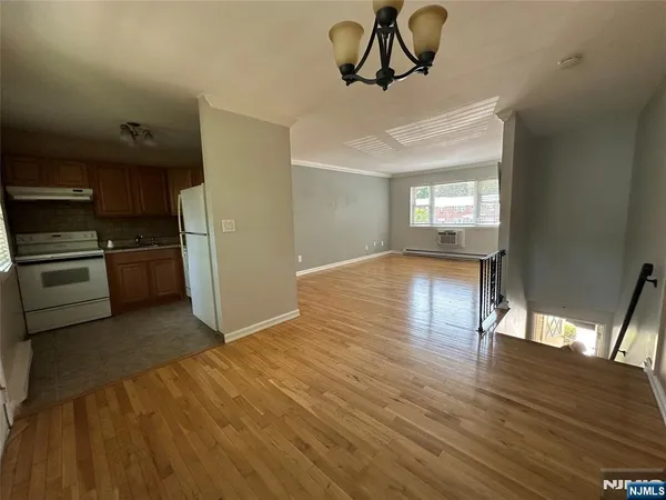 a view of empty room with kitchen and window