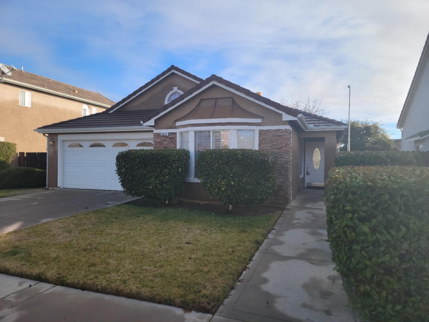 a front view of a house with a yard and garage