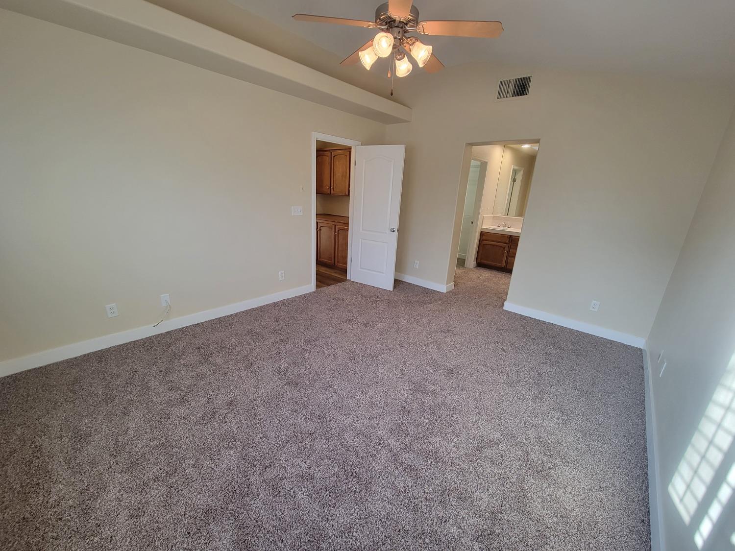 2831 Isabel Avenue Clovis, CA 93611 - Photo 12 of 27 an empty room with a chandelier fan and windows