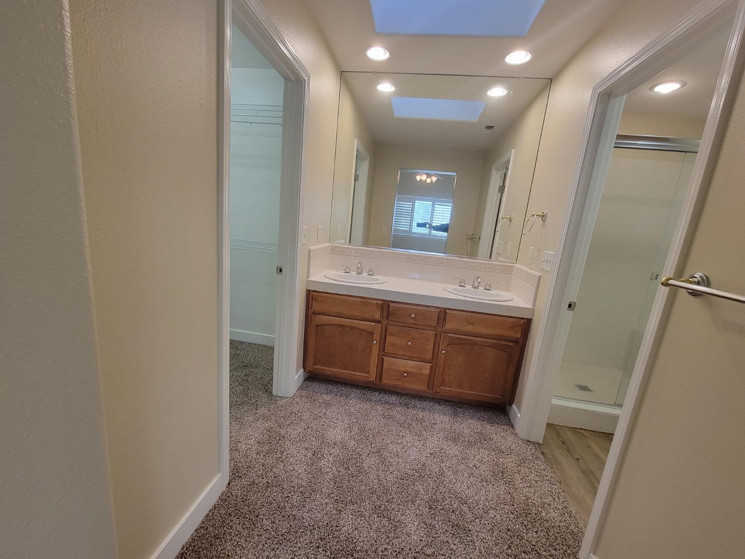 2831 Isabel Avenue Clovis, CA 93611 - Photo 13 of 27 a bathroom with a double vanity sink and mirror