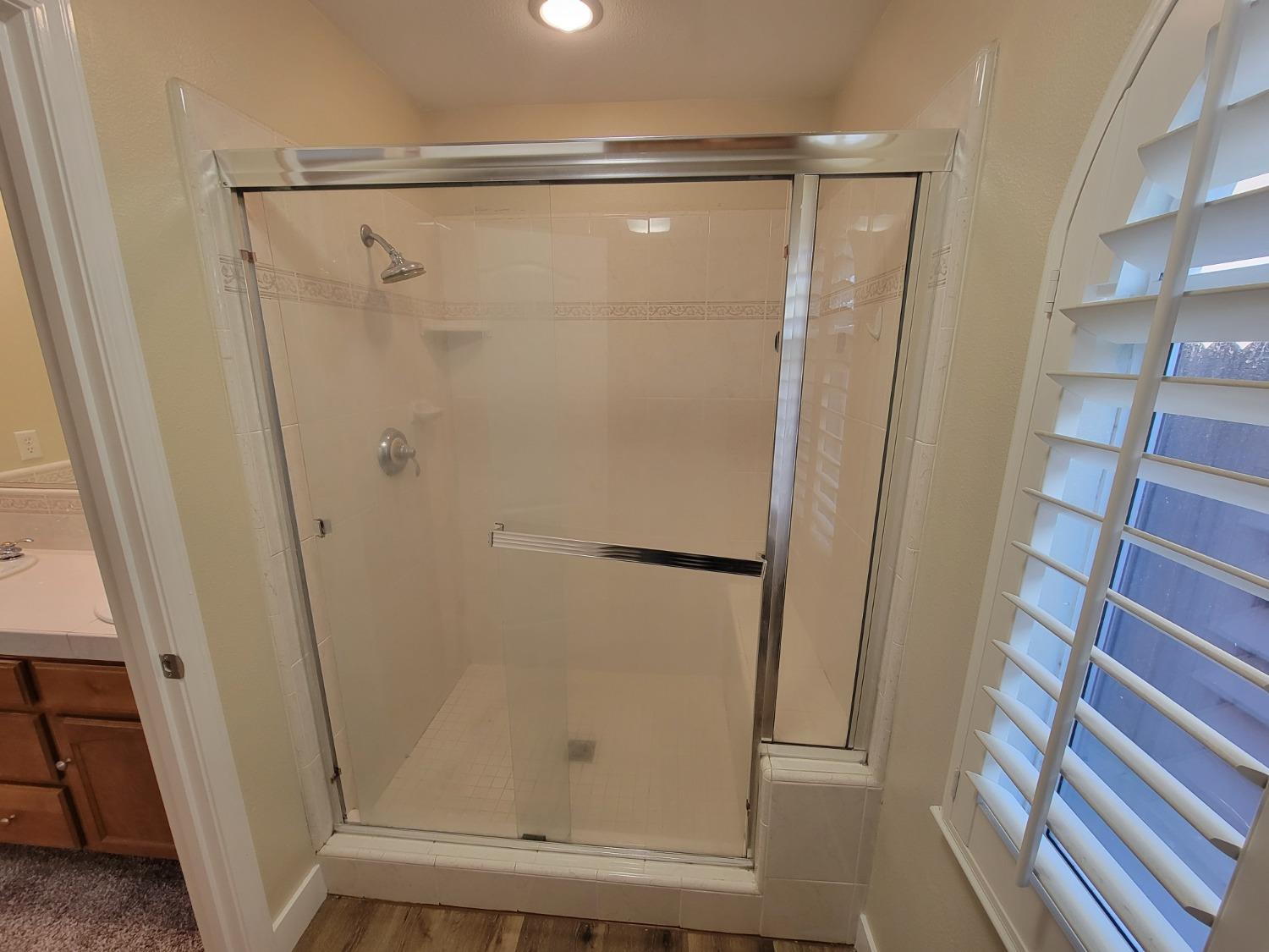 2831 Isabel Avenue Clovis, CA 93611 - Photo 16 of 27 a bathroom with a glass door shower and a sink