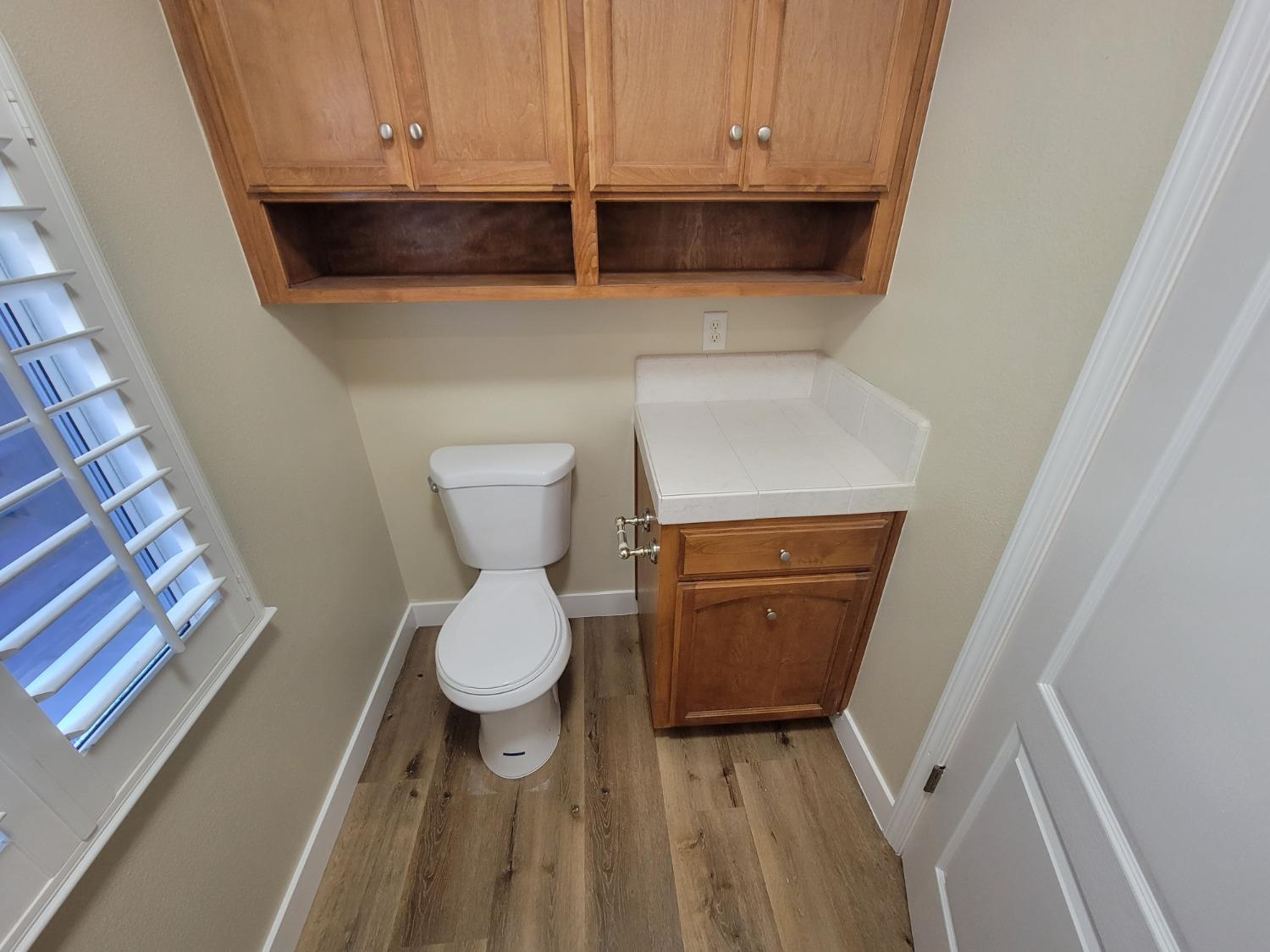 2831 Isabel Avenue Clovis, CA 93611 - Photo 17 of 27 a bathroom with a toilet and a wooden floor