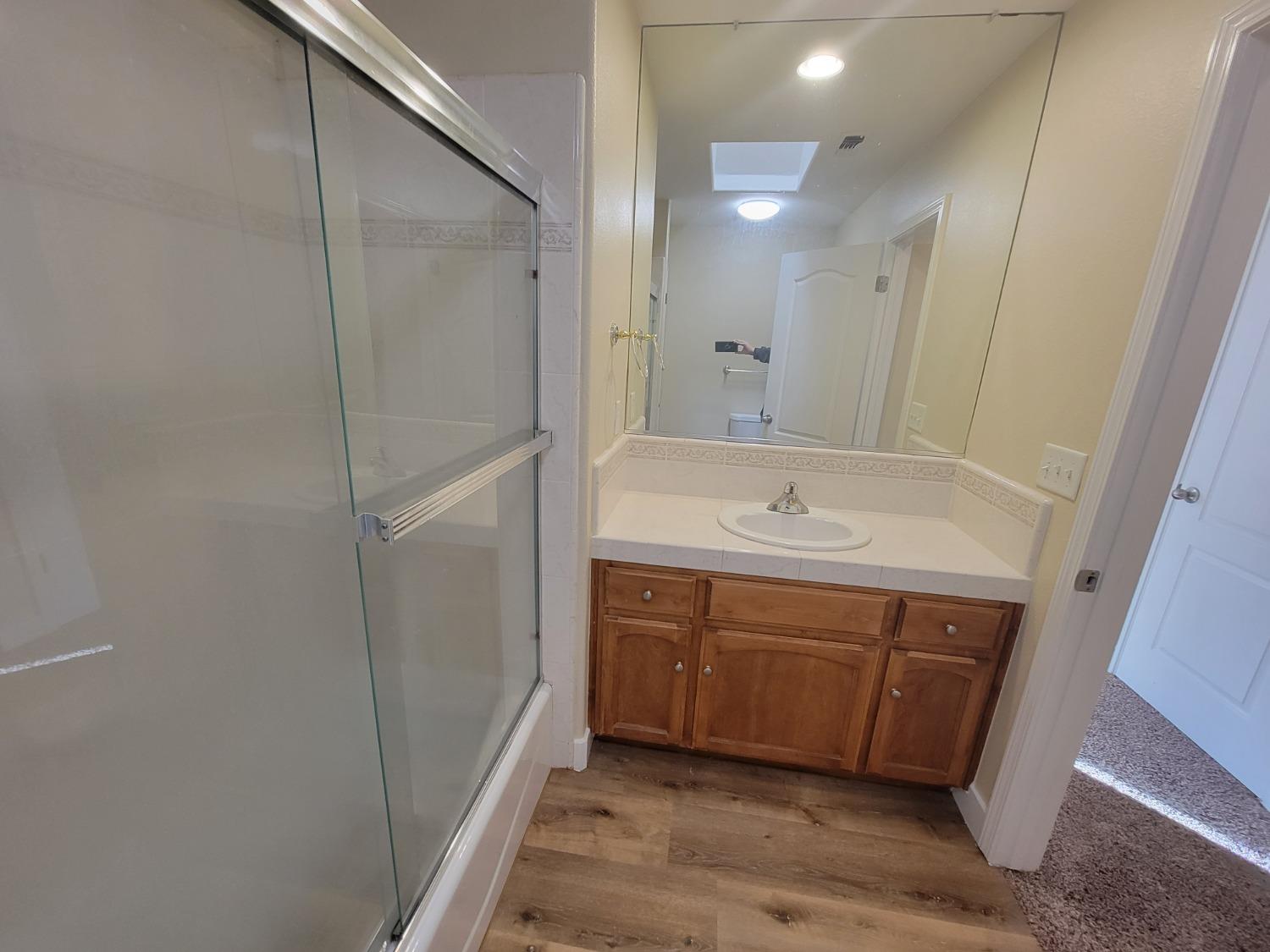 2831 Isabel Avenue Clovis, CA 93611 - Photo 21 of 27 a bathroom with a sink a mirror and a shower