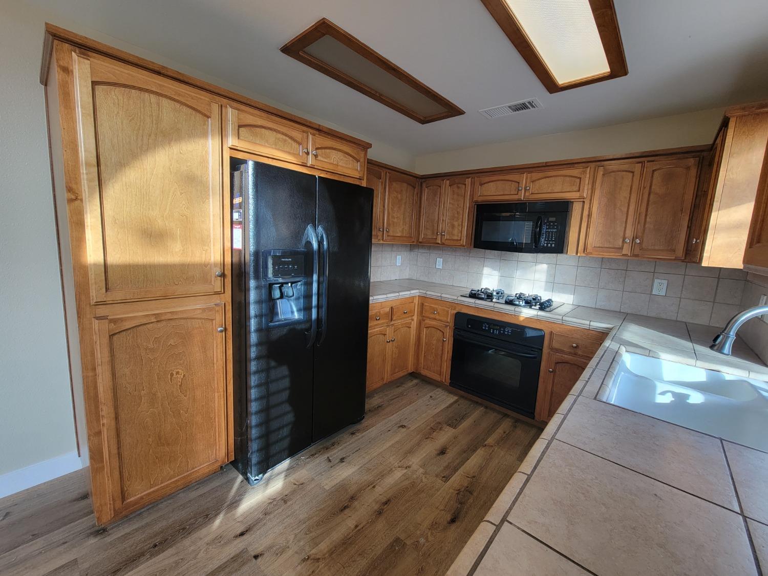 2831 Isabel Avenue Clovis, CA 93611 - Photo 9 of 27 a kitchen with stainless steel appliances granite countertop a refrigerator a stove top oven a sink and dishwasher