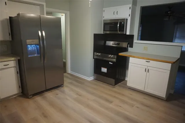 a kitchen with stainless steel appliances granite countertop a refrigerator and a stove