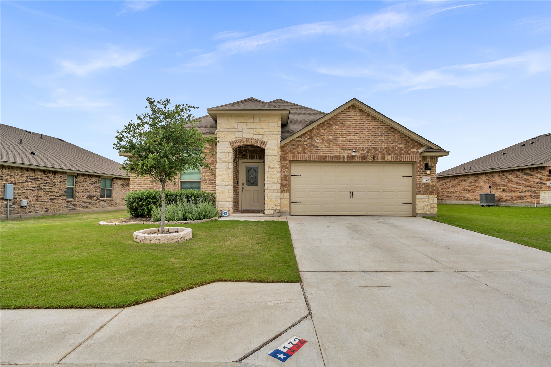 132 Cinnamon Loop Burnet, TX 78611 - Photo 2 of 27 Brick and stone veneer exterior with a two-car garage