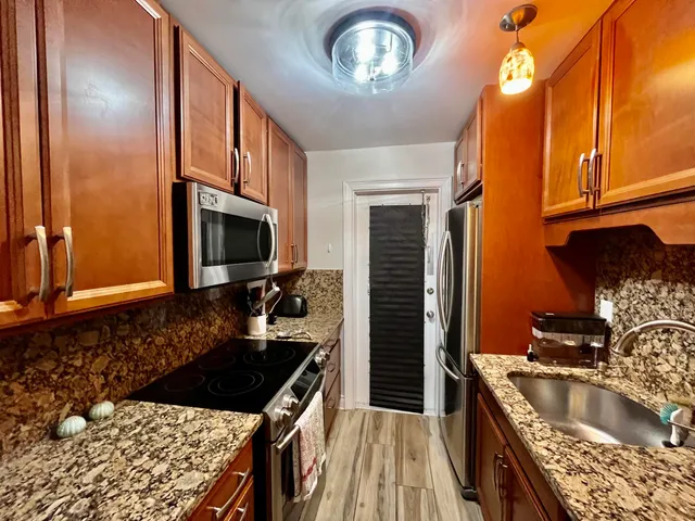 a kitchen with stainless steel appliances granite countertop a sink stove and refrigerator