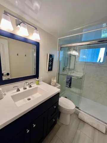 a bathroom with a sink vanity mirror and toilet
