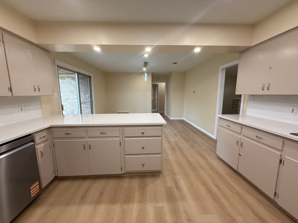 4603 Roundup Trail Austin, TX 78745 - Photo 12 of 35 Kitchen with dishwasher, light wood finished floors, a peninsula, light stone counters, and recessed lighting