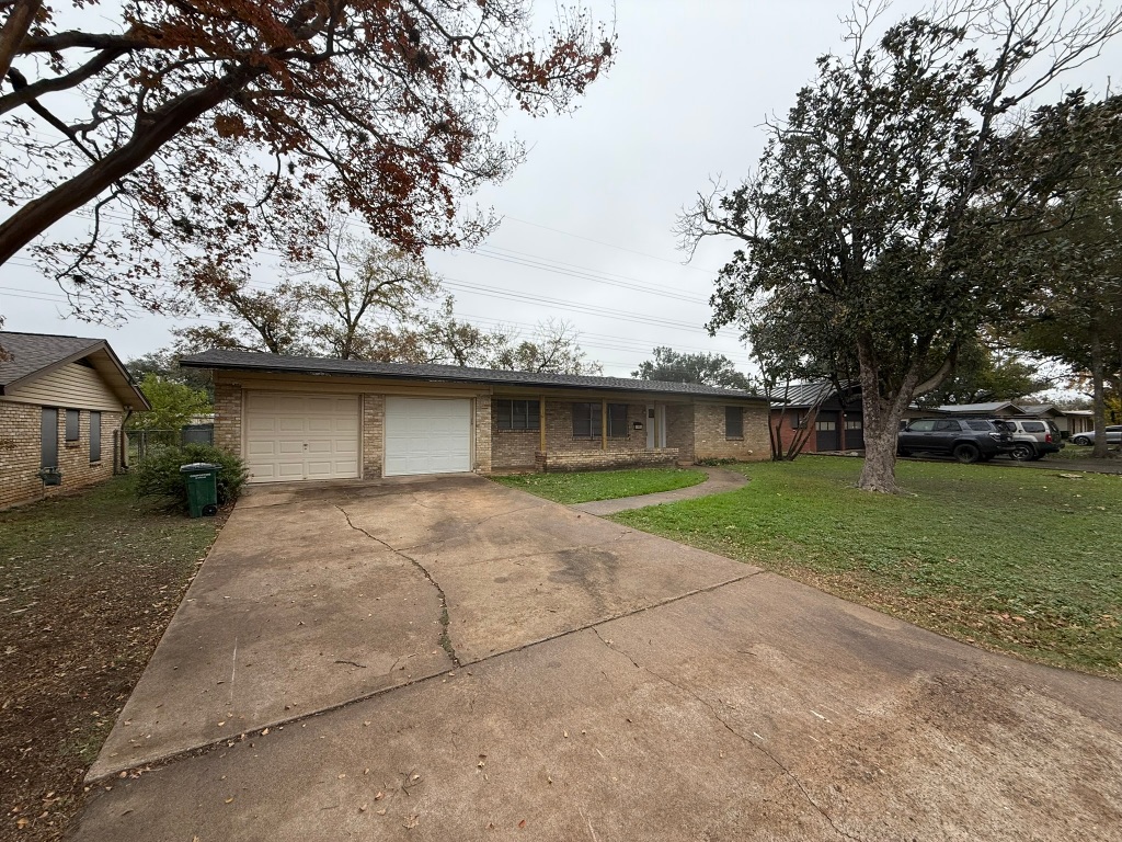 4603 Roundup Trail Austin, TX 78745 - Photo 2 of 35 Single story home with a front lawn, brick siding, driveway, and an attached garage