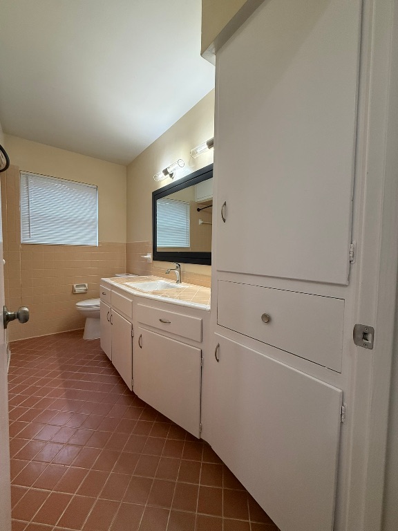 4603 Roundup Trail Austin, TX 78745 - Photo 23 of 35 Full bathroom with vanity, dark tile patterned floors, and tile walls