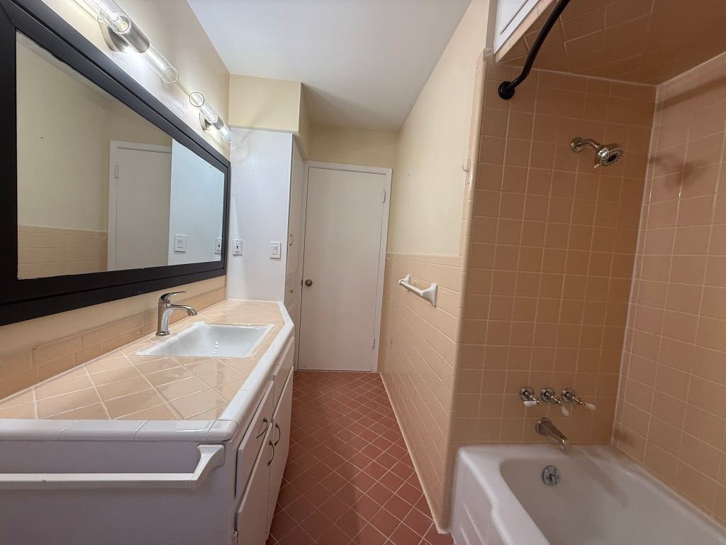 4603 Roundup Trail Austin, TX 78745 - Photo 25 of 35 Bathroom with vanity, shower / bathtub combination, tile walls, and wainscoting