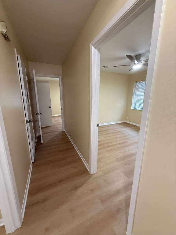 4603 Roundup Trail Austin, TX 78745 - Photo 27 of 35 Hallway featuring light wood-style floors and baseboards