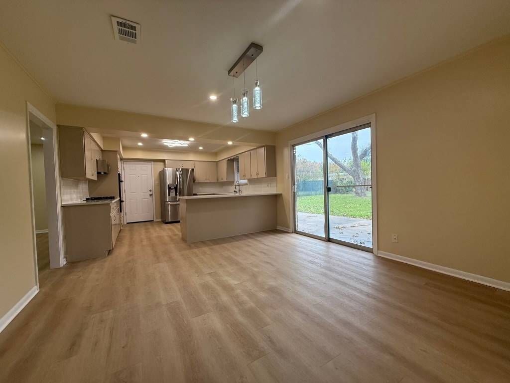 4603 Roundup Trail Austin, TX 78745 - Photo 34 of 35 Kitchen with open floor plan, light countertops, stainless steel fridge with ice dispenser, recessed lighting, and light wood-type flooring