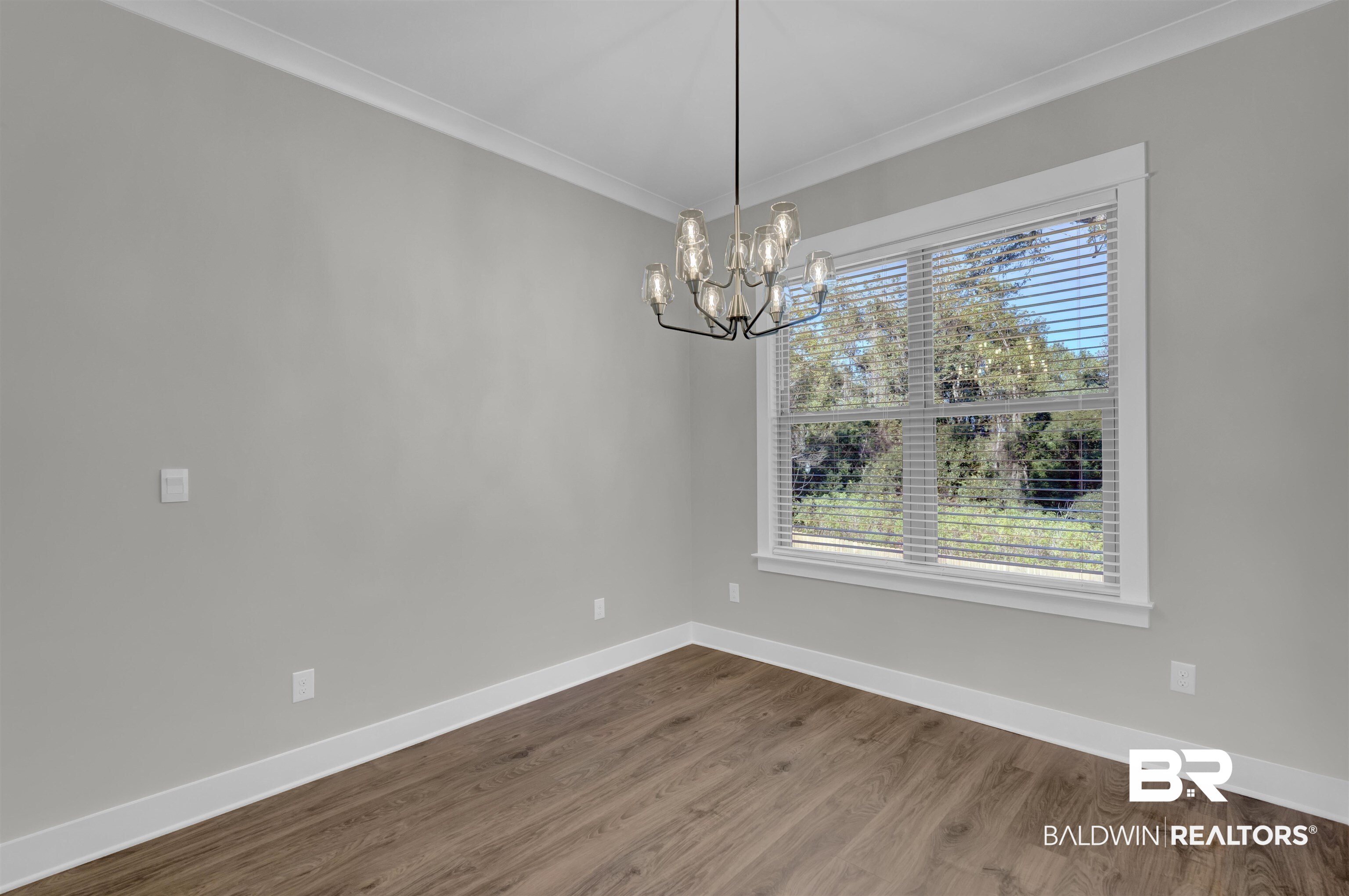 571 Morning Mist Way Fairhope, AL 36532 - Photo 12 of 47 Unfurnished dining area featuring ornamental molding, dark wood-type flooring, and a chandelier