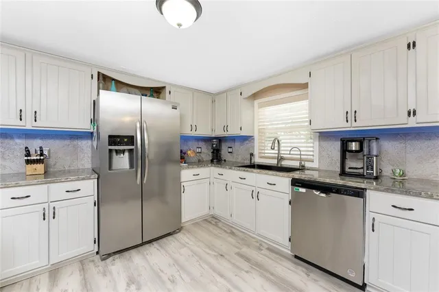 a kitchen with stainless steel appliances granite countertop a refrigerator sink and cabinets