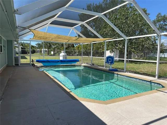 a view of a backyard with swimming pool and porch