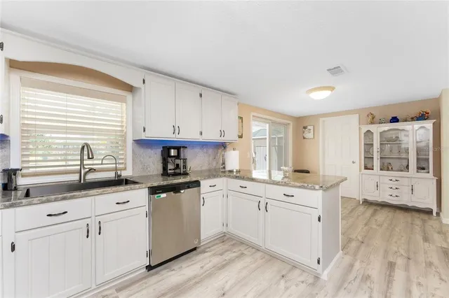a kitchen with a sink a window and cabinets