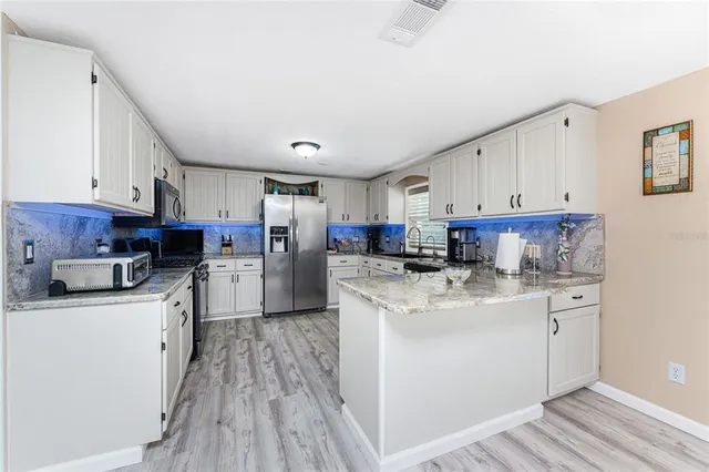 a kitchen with appliances a sink and cabinets