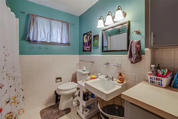 a bathroom with a sink mirror and toilet