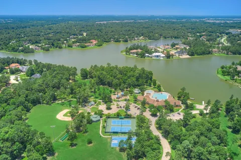 an aerial view of a house with a yard and large trees