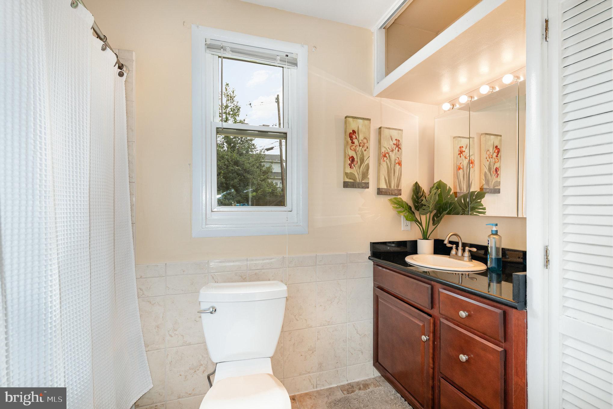 5005 Catalpha Road Baltimore, MD 21214 - Photo 13 of 31 a bathroom with a sink a toilet and mirror