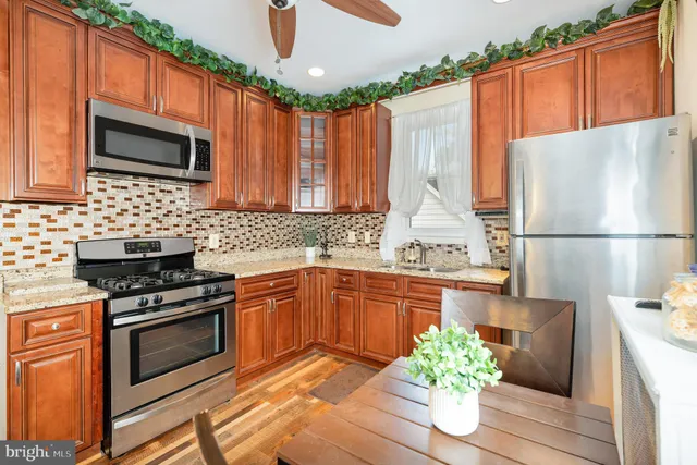 a kitchen with stainless steel appliances granite countertop a refrigerator sink stove microwave and cabinets
