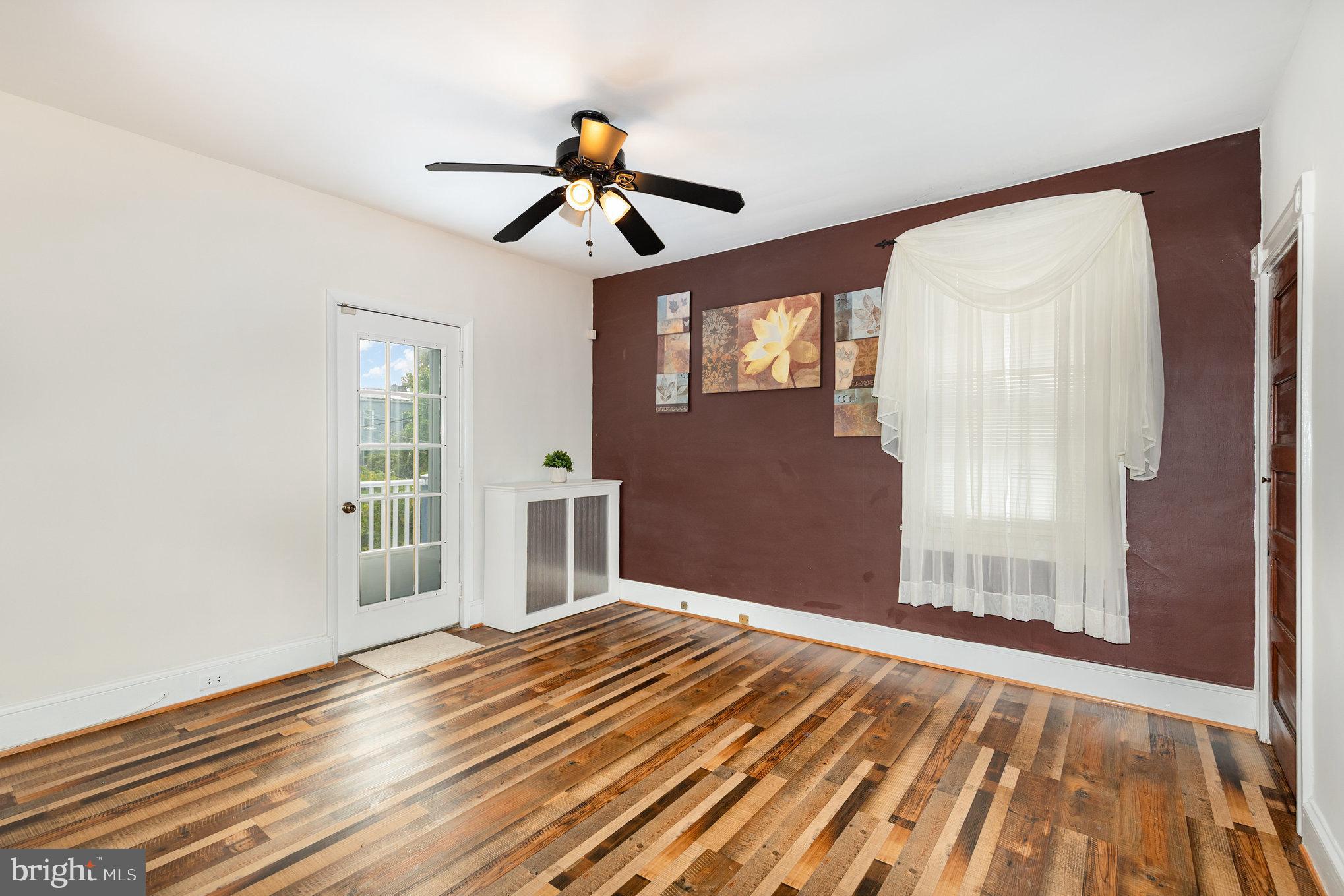 5005 Catalpha Road Baltimore, MD 21214 - Photo 19 of 31 a view of a livingroom with wooden floor and a ceiling fan