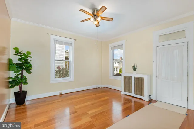 a view of a livingroom with wooden floor and a ceiling fan