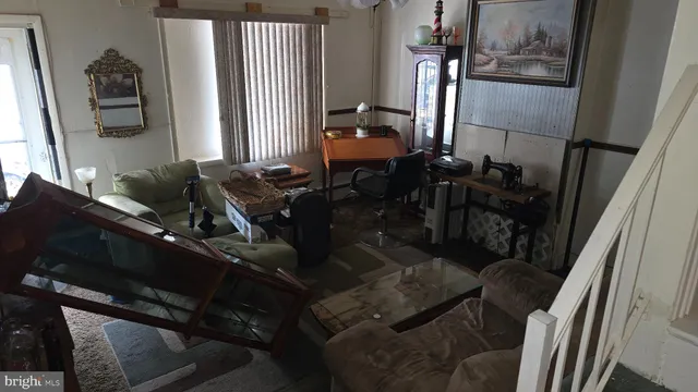 a living room with furniture and a painting on the wall