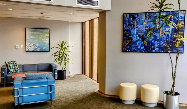 a living room with furniture and a painting on the wall