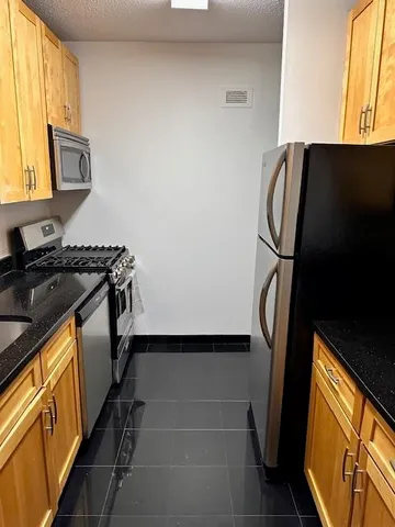 a kitchen with kitchen island granite countertop a sink and a stove