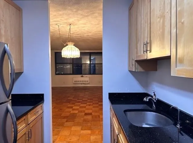 a kitchen with granite countertop a sink and a refrigerator