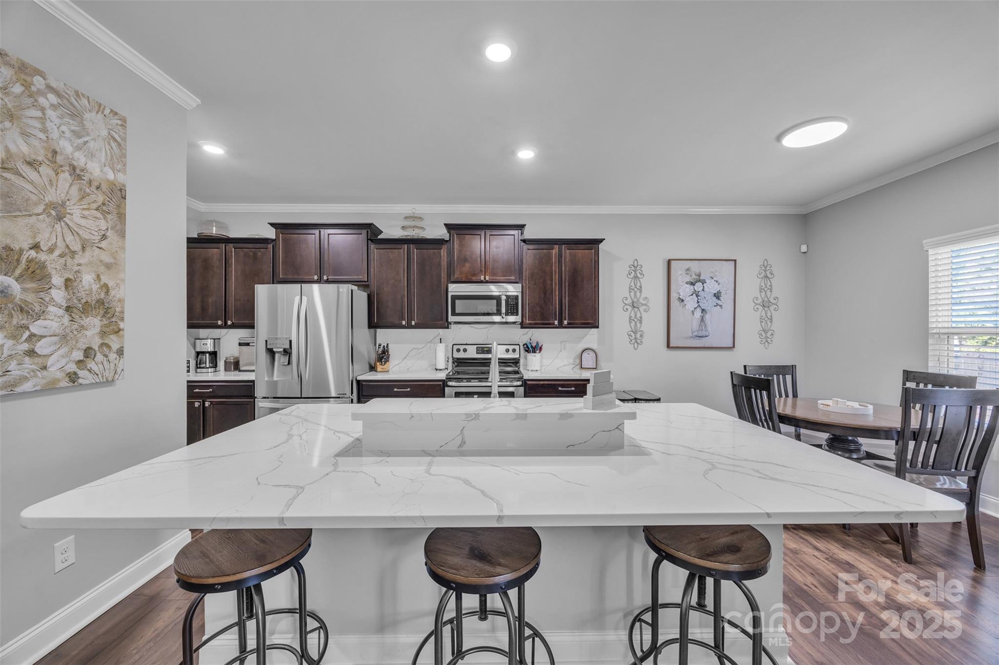 19455 Smith Circle Cornelius, NC 28031 - Photo 7 of 24 a kitchen with stainless steel appliances a dining table chairs and refrigerator