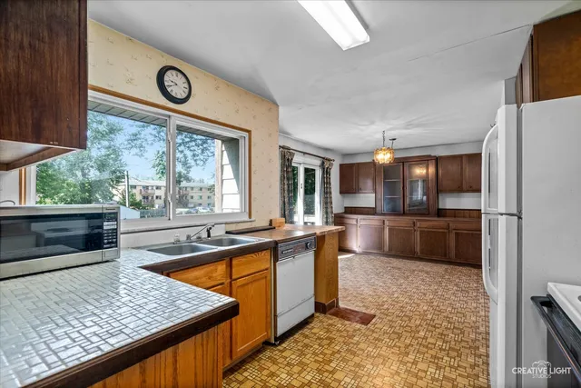 a kitchen with stainless steel appliances kitchen island granite countertop a refrigerator and a stove top oven