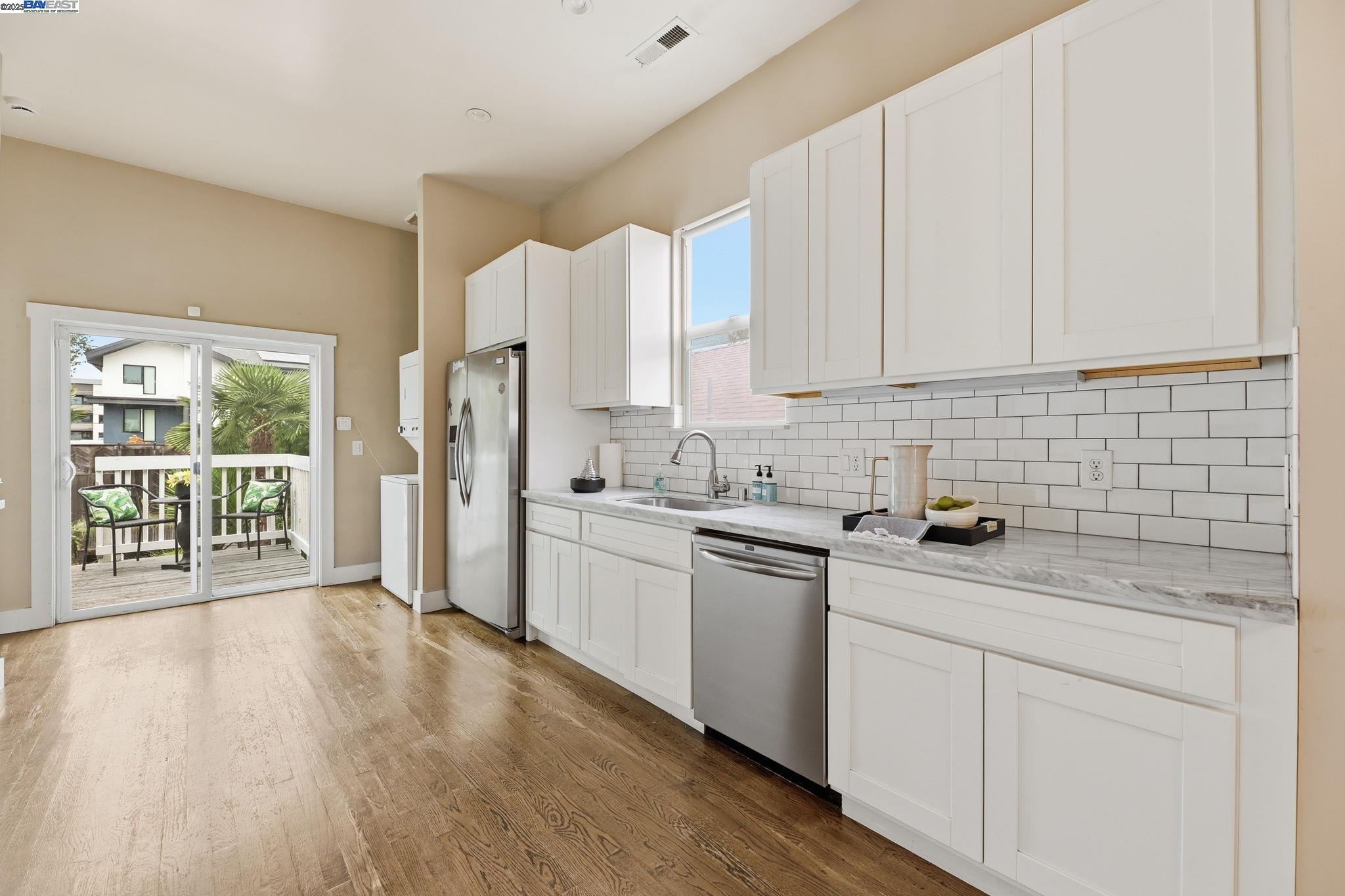 2417 Linden Street Oakland, CA 94607 - Photo 12 of 41 a kitchen with stainless steel appliances granite countertop a stove a sink dishwasher a refrigerator and white cabinets with wooden floor