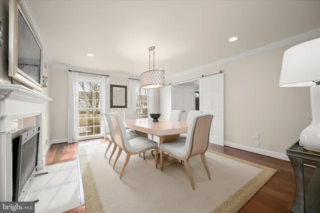 a kitchen with stainless steel appliances granite countertop a refrigerator a oven a sink and a dining table with wooden floor