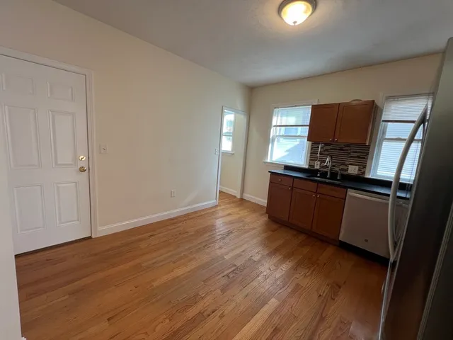 a kitchen with wooden floors and black appliances
