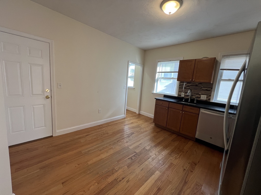 12 Weld Hill Street, Unit 2 Boston, MA 02130 - Photo 5 of 9 a kitchen with wooden floors and black appliances