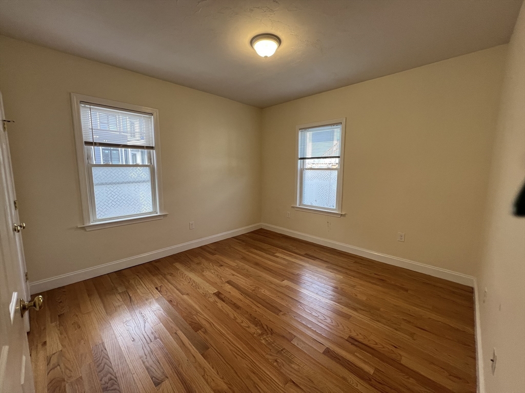 12 Weld Hill Street, Unit 2 Boston, MA 02130 - Photo 7 of 9 an empty room with wooden floor and windows